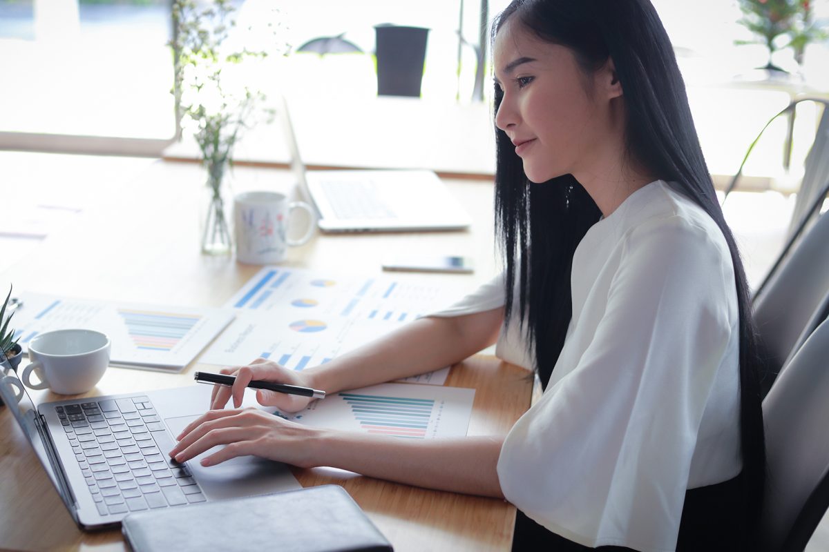 Asian business woman working in in coffee shop cafe with laptop paper work  (Business woman concept.)